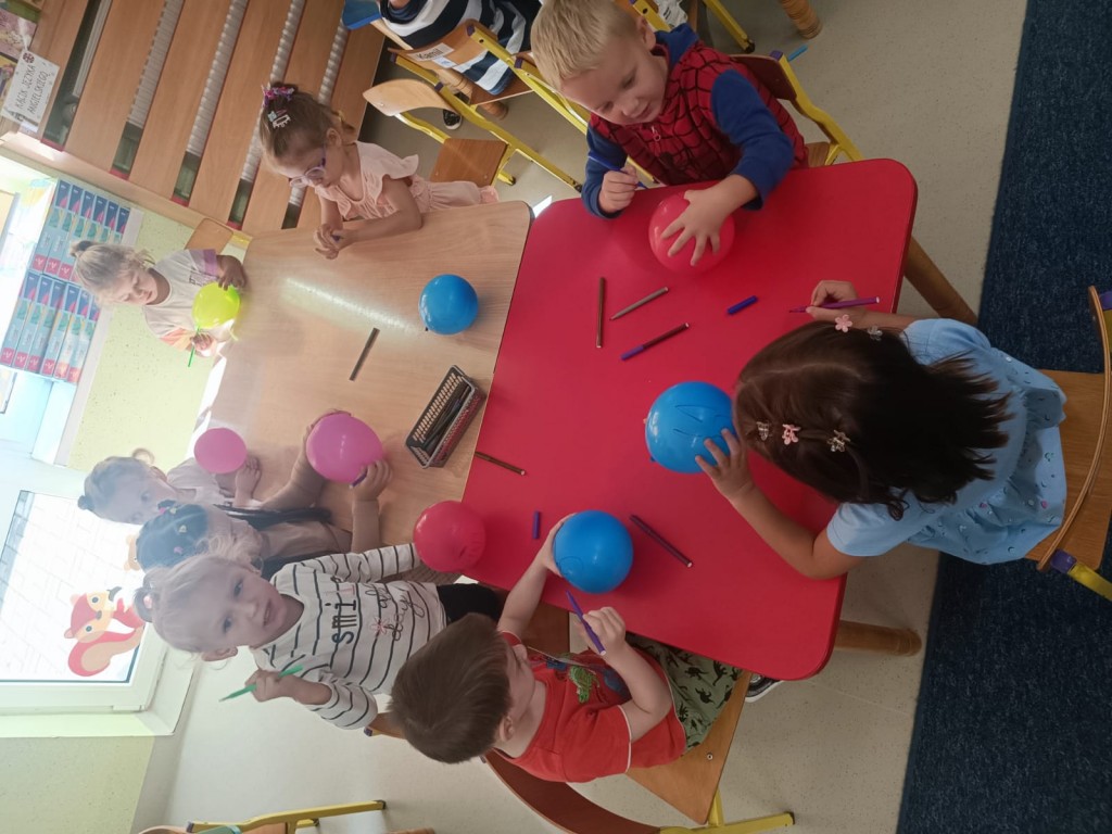 Dzieci ozdabiają kolorowe balony.