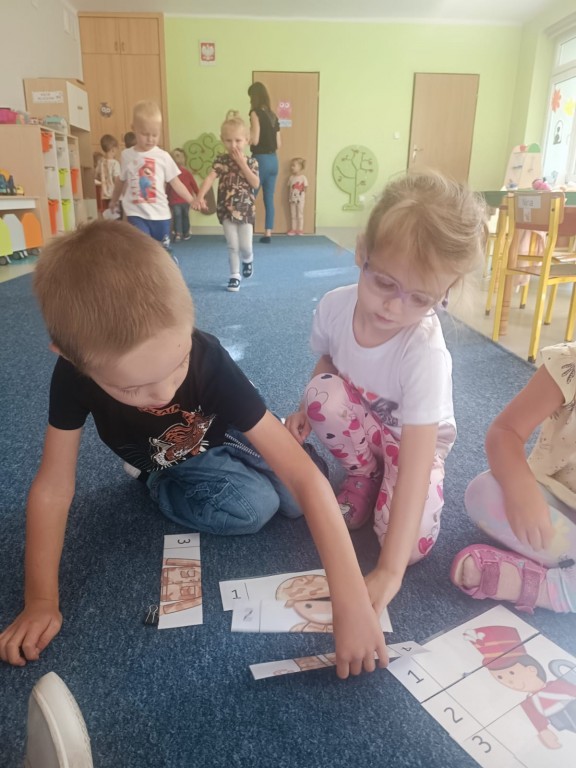 Chłopiec i dziewczynka układają puzzle.