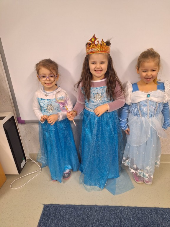 Trzy dziewczynki stoją przebrane za księżniczki