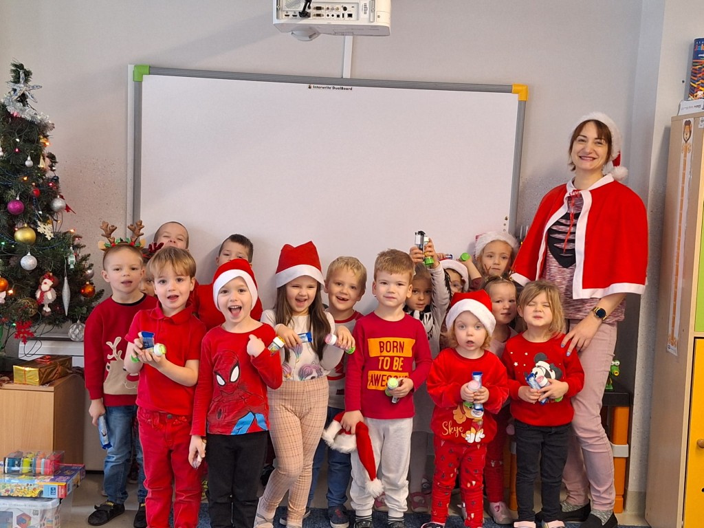 Dzieci wraz z nauczycielką pozują do zdjęcia ubrane na czerwono