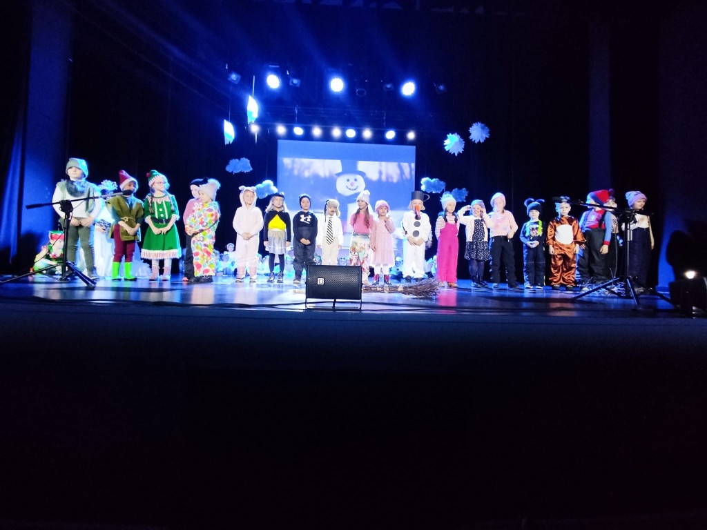 Dzieci stoja na scenie i przedstawiaja opowiesc o balwanku