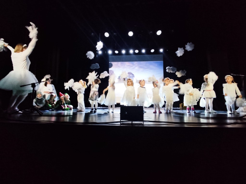Dzieci ubrane na bialo tancza z pomponami do muzyki