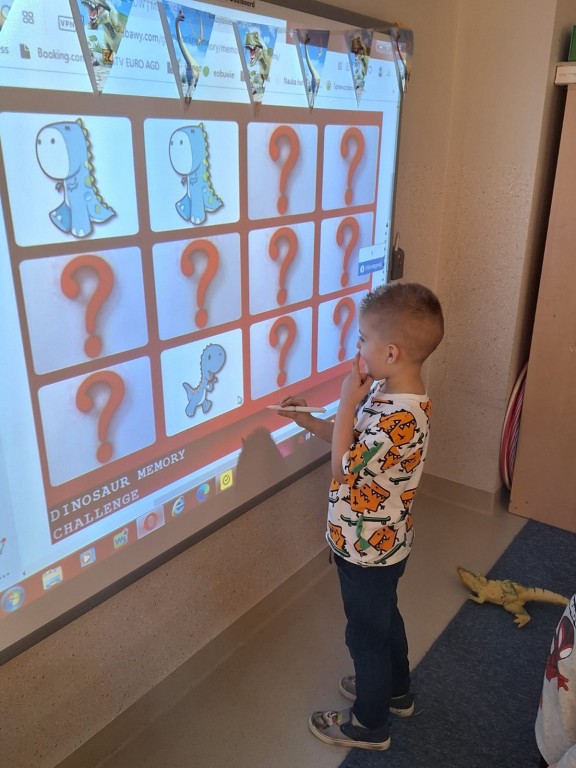 Chłopiec bawi się w memory przy użyciu  tablicy interaktywnej