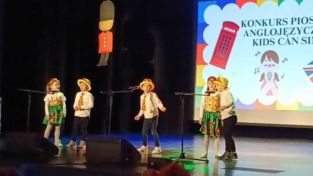 Dzieci spiewaja do mikrofonu piosenke po angielsku