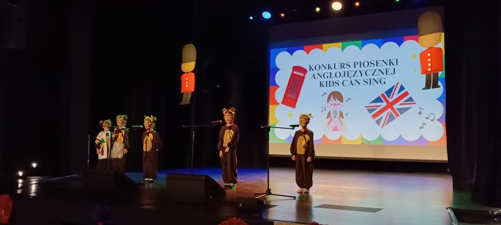dzieci przebrane za malpki spiewaja po angielsku na scenie