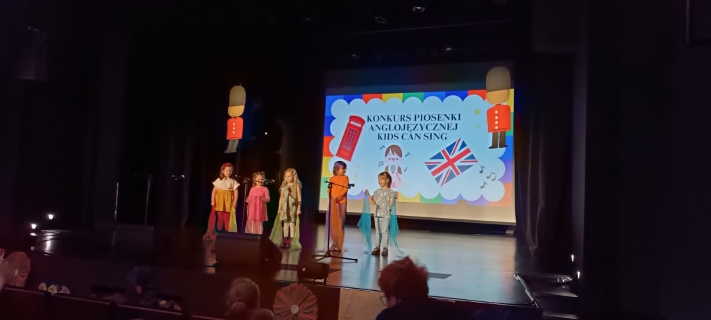 dzieci z kolorowymi chustami spiewaja po angielsku