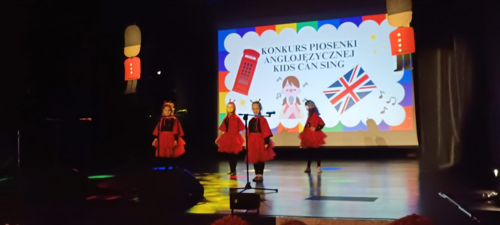 dziewczynki biedronki spiewaja piosenke na scenie w jezyku angielskim