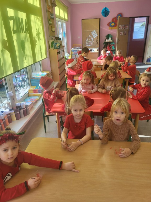 Dzieci siedzą przy stolikach jedzą galaretki 