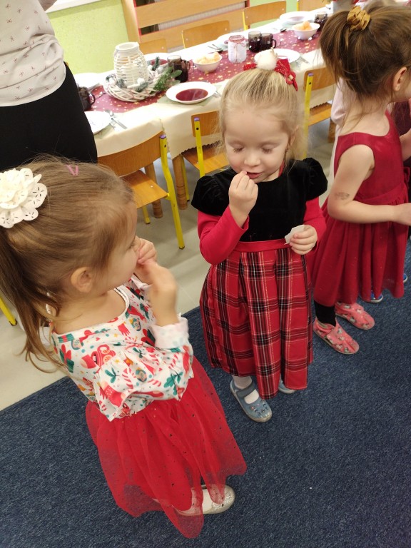 dzieci dziela sie oplatkiem i skladaja sobie zyczenia