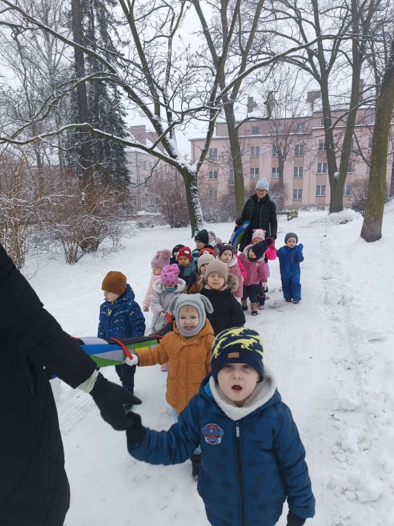 dzieci idą w parach po śniegu