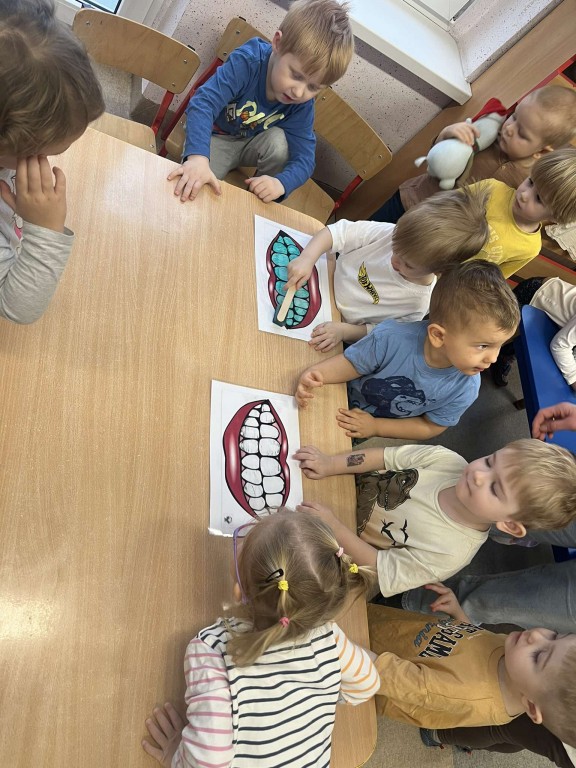 dzieci czyszczą planszę z zębami