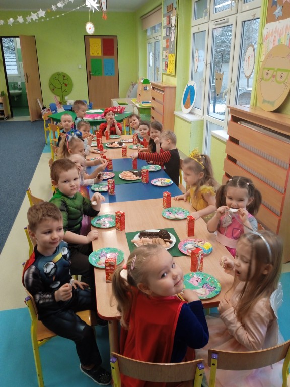 dzieci jedza slodki poczestunek na balu karnawalowym