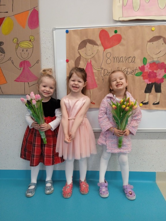 dziewczynki trzymaja tulipany z okazji dnia kobiet