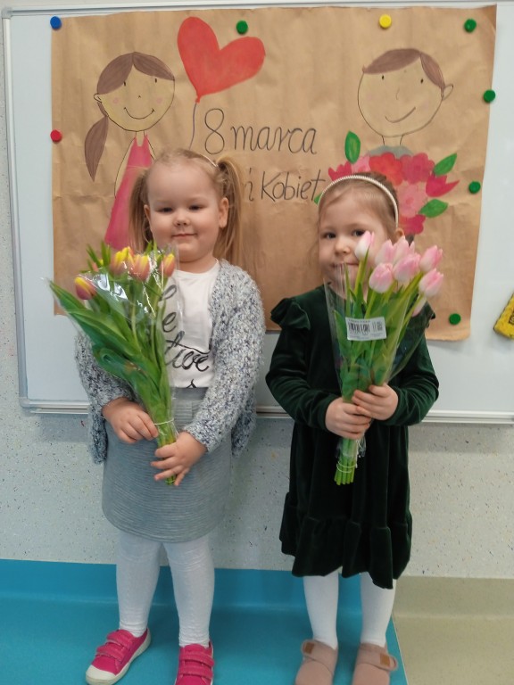 dziewczynki trzymaja tulipany z okazji dnia kobiet