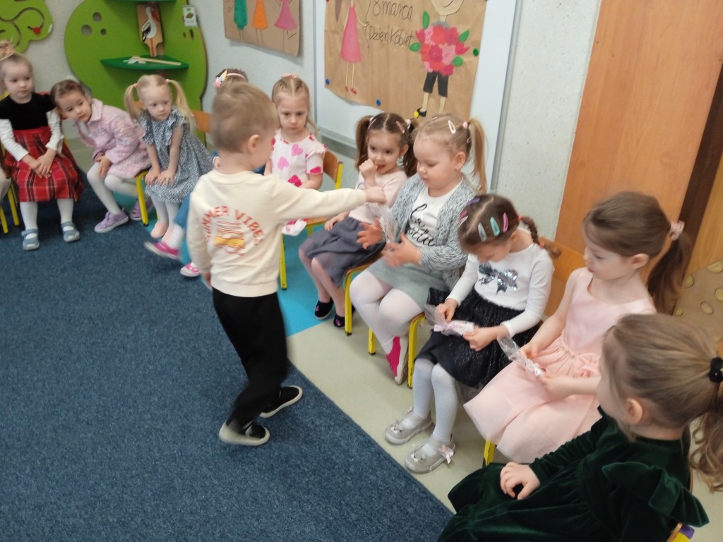 chlopiec wrecza prezent z okazji dnia kobiet