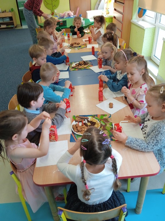 dzieci jedza slodki poczestunek z okazji dnia kobiet
