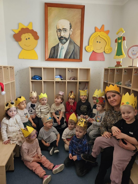 Zdjęcie grupowe w koronach pod portretem patronA