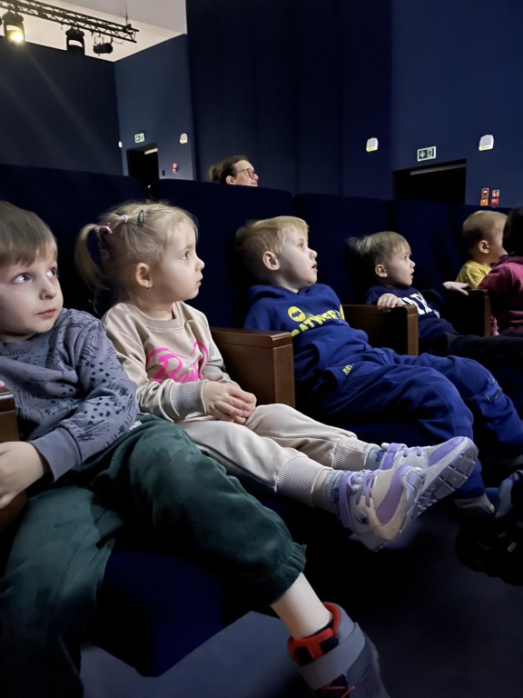 Dzieci siedzą na krzesłąch na widowni