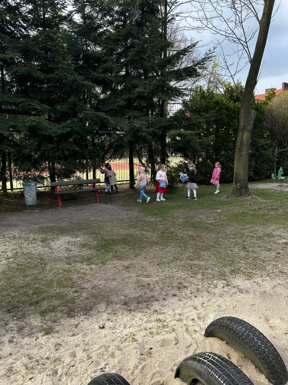 Dzieci szukają na podworku prezentów od zajączka