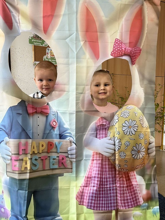 para dzieci pozuje do zdjęciaw w wielkanocnej fotobudce
