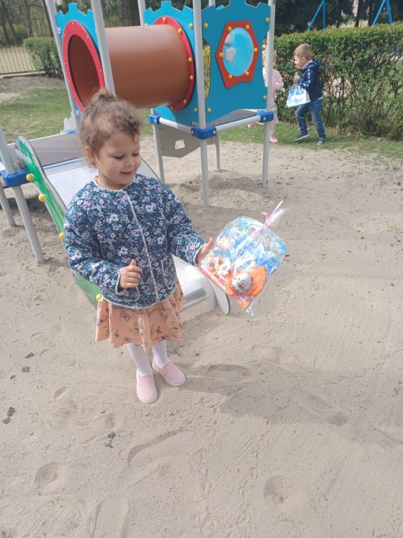 dziewczynka znalazla prezent od zajaczka w ogrodzie przedszkolnym