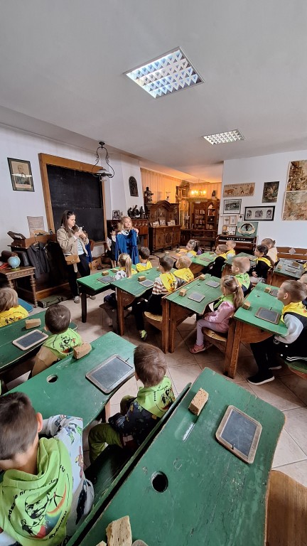 Dzieci siedzą w ławkach
