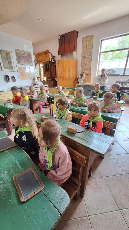 Dzieci siedzą w ławkach