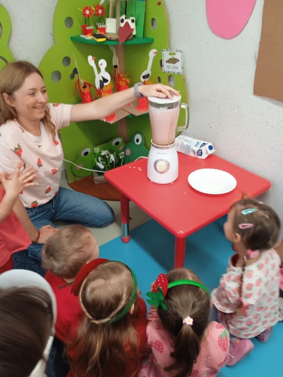 dzieci robia koktajl truskawkowy w blenderze