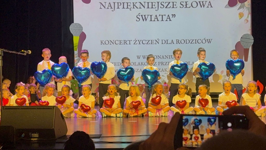 grupa starszakow wystepuje w domu kultury dla rodzicow