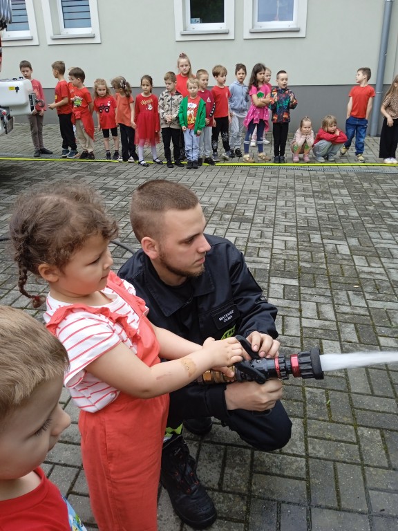 dzieci trzymaja weza strazackiego