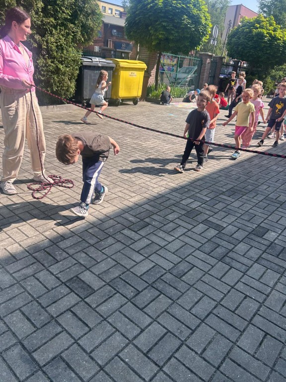 Dzieci przechodzą pod liną