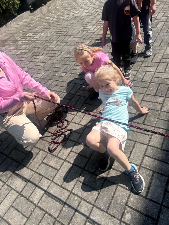 Dzieci przechodzą pod liną