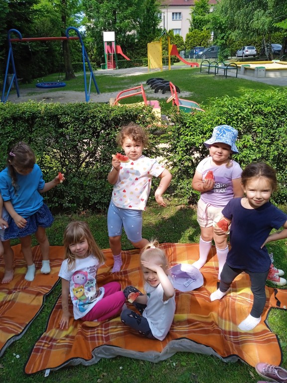 dzieci jedza arbuzy na kocu