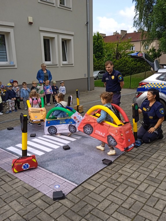 dzieci jako samochodziki jezdza po drodze