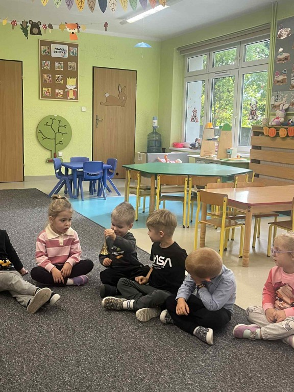 dzieci podają sobie dzwonek-zabawa wyciszająca