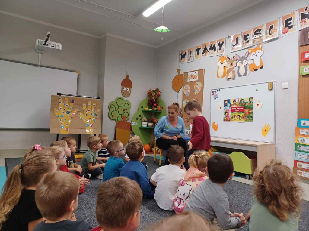 Dzieci patrzą na tablicę i słuchają nauczyciela