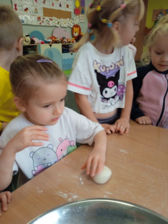 dziewczynka robi z masy solnej bulke