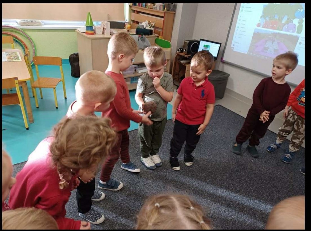 dzieci podają sobie buraka z ręki do ręki w kole