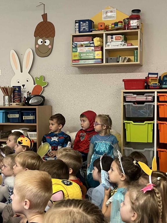 Dzieci z zaciekawieniem oglądają pokaz magii