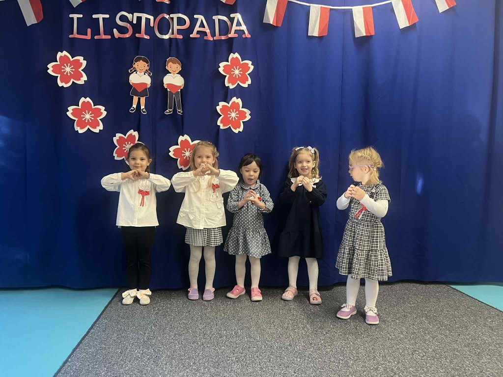 Dziewczynki ubrane elegancko pokazują serduszka dla Polski