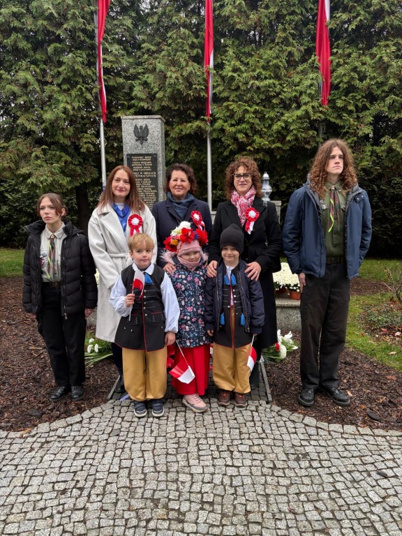 Dzieci stoją pod pomnikiem 