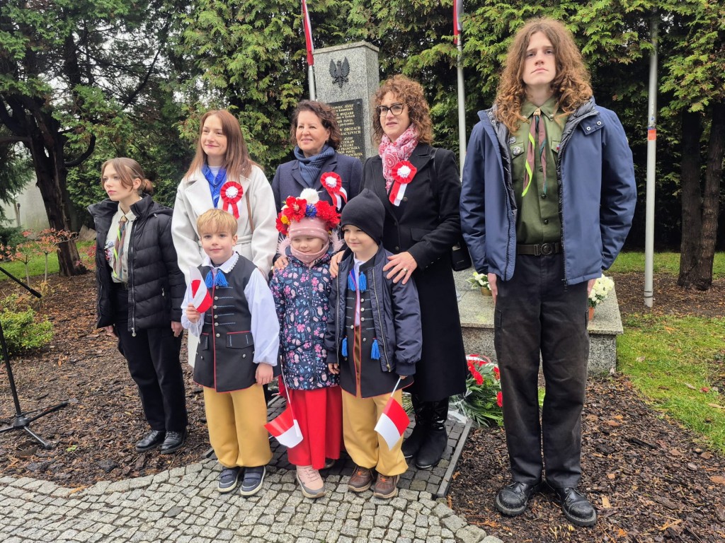 Dzieci stoją pod pomnikiem 