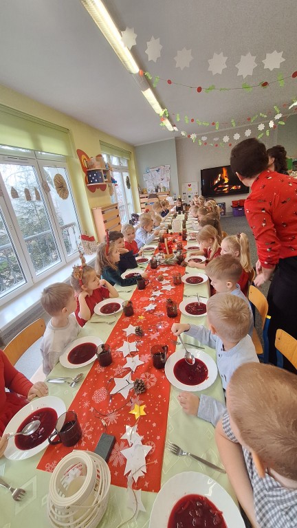 Dzieci siedzą przy stole wigilijnym 