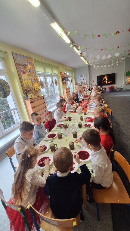 Dzieci siedzą przy stole wigilijnym 