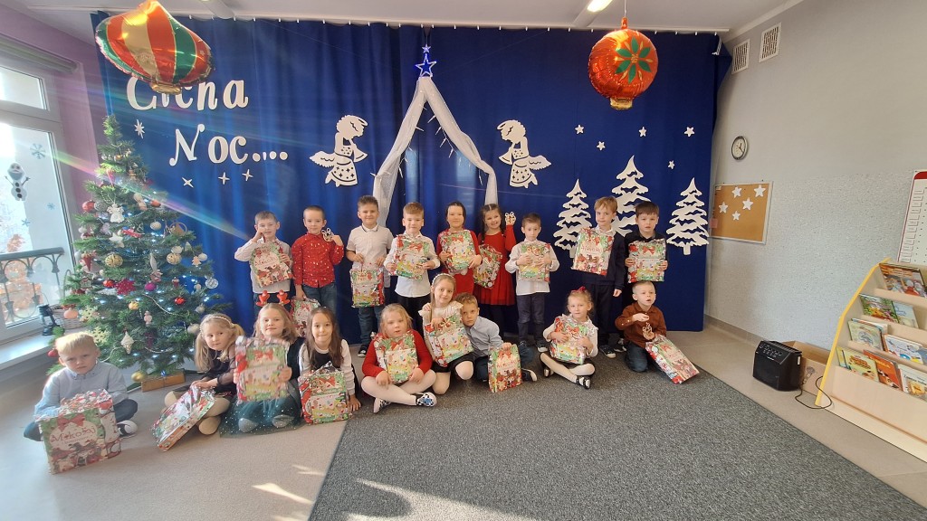 Dzieci pozują  do zdjęcia z prezentami od dzieciątka 