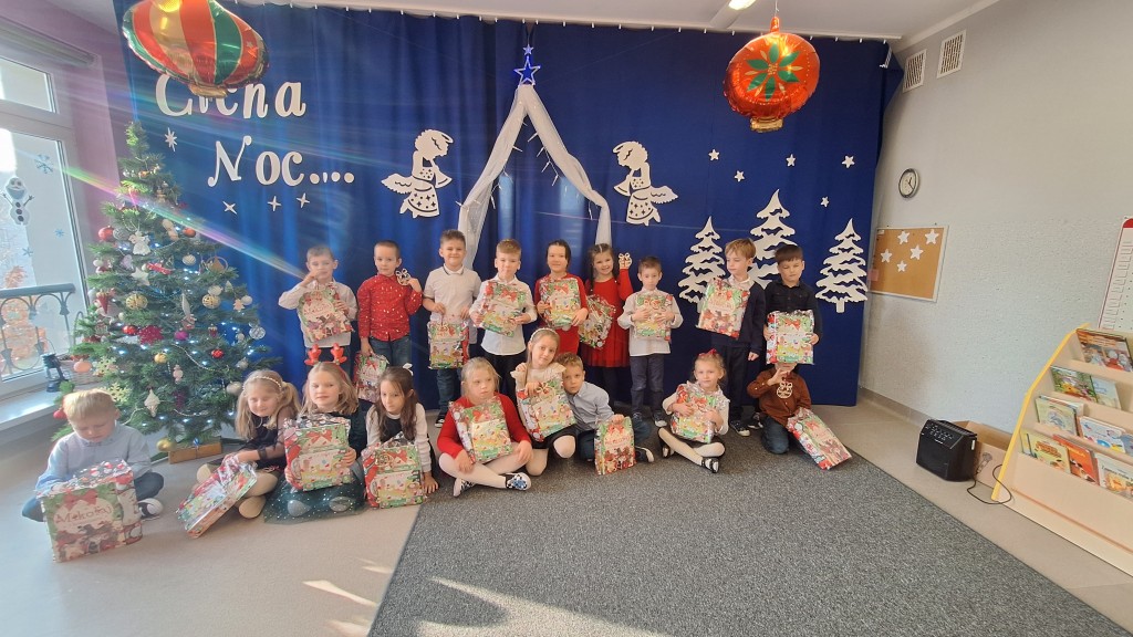 Dzieci  pozują do zdjęcia z prezentami od dzieciątka 