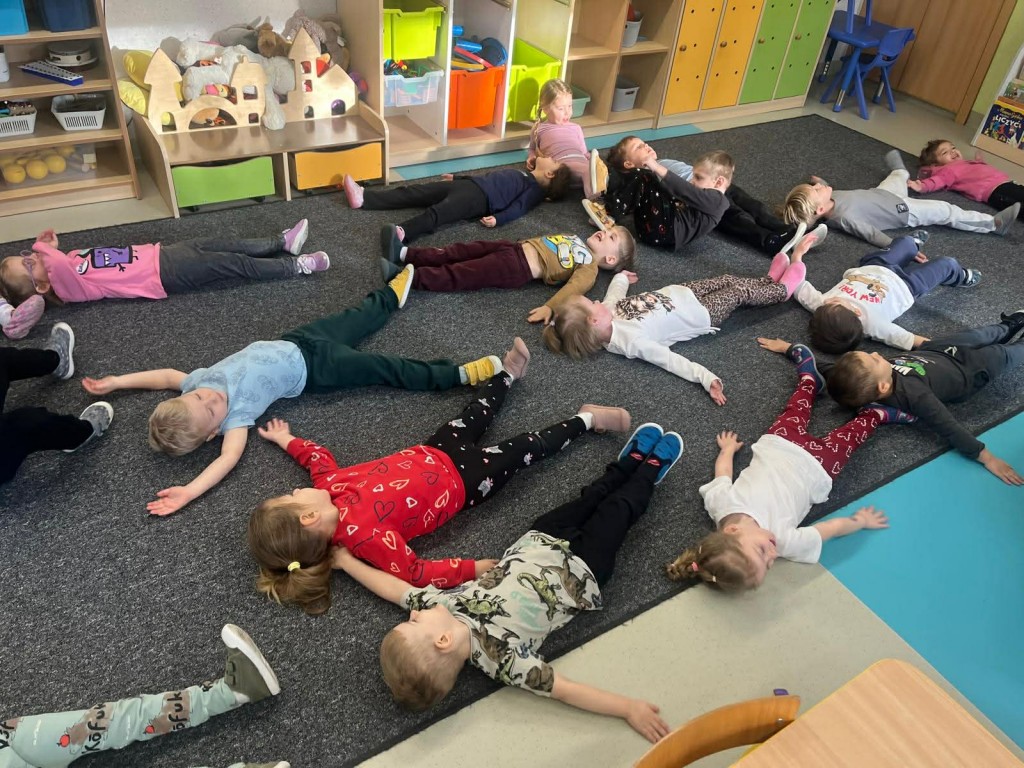 dzieci naśladują robienie aniołków na śniegu