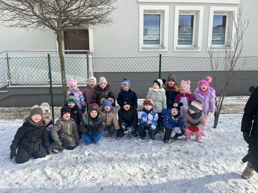 zdjęcie grupowe grupy pod budynkiem przedszkola