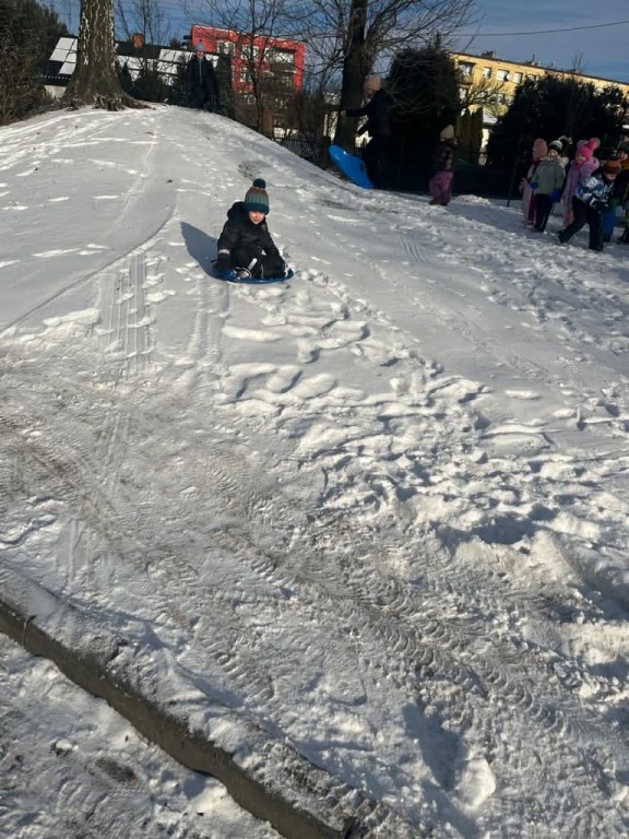 chłopiec zjeżdża z górki na ślizgu