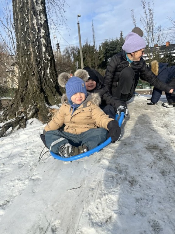 dwoje chłopców siedzi na saneczkach